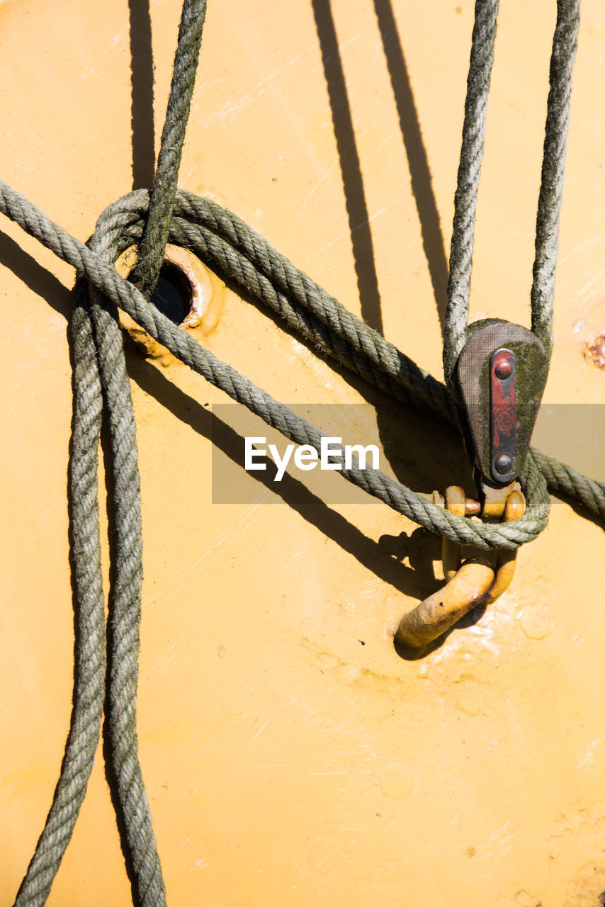 CLOSE-UP OF ROPE TIED TO FENCE