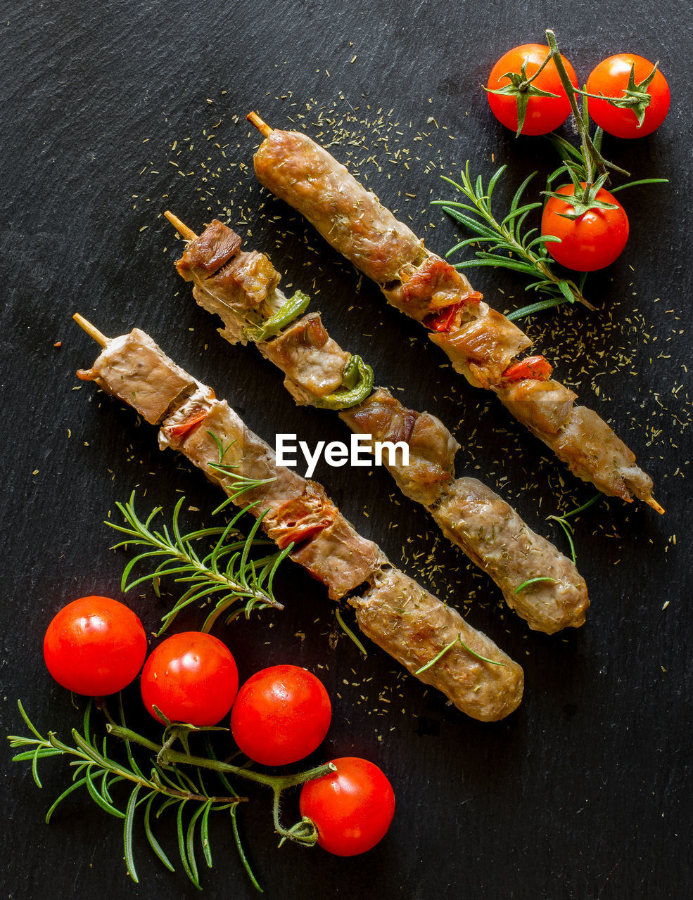 Skewers of mixed meat and grilled vegetables on slate