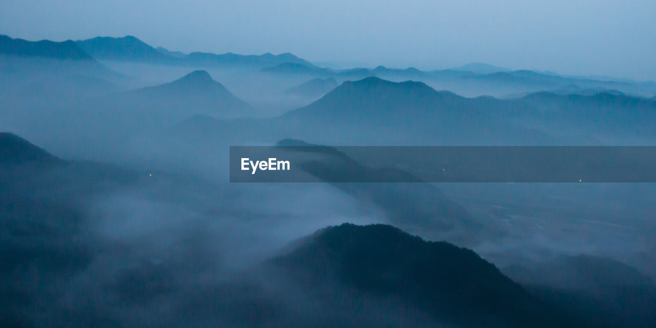 Scenic view of mountains against blue sky