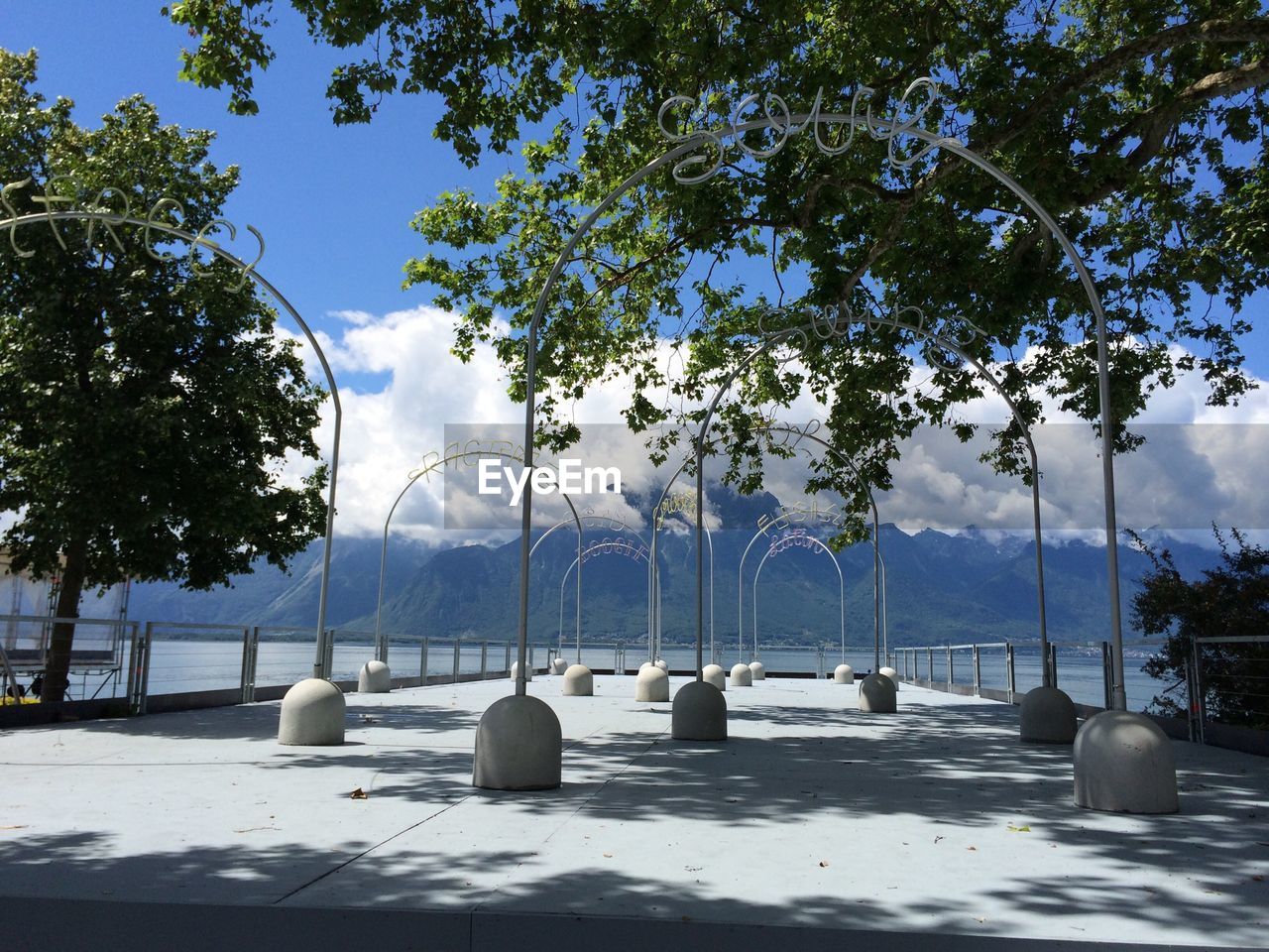 Lake against mountain range with arched way in foreground