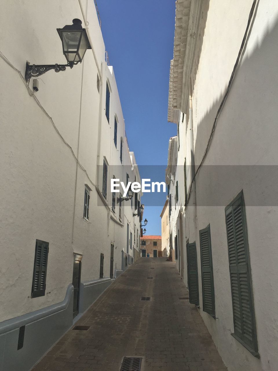 Low angle view of street amidst buildings against sky at alaior