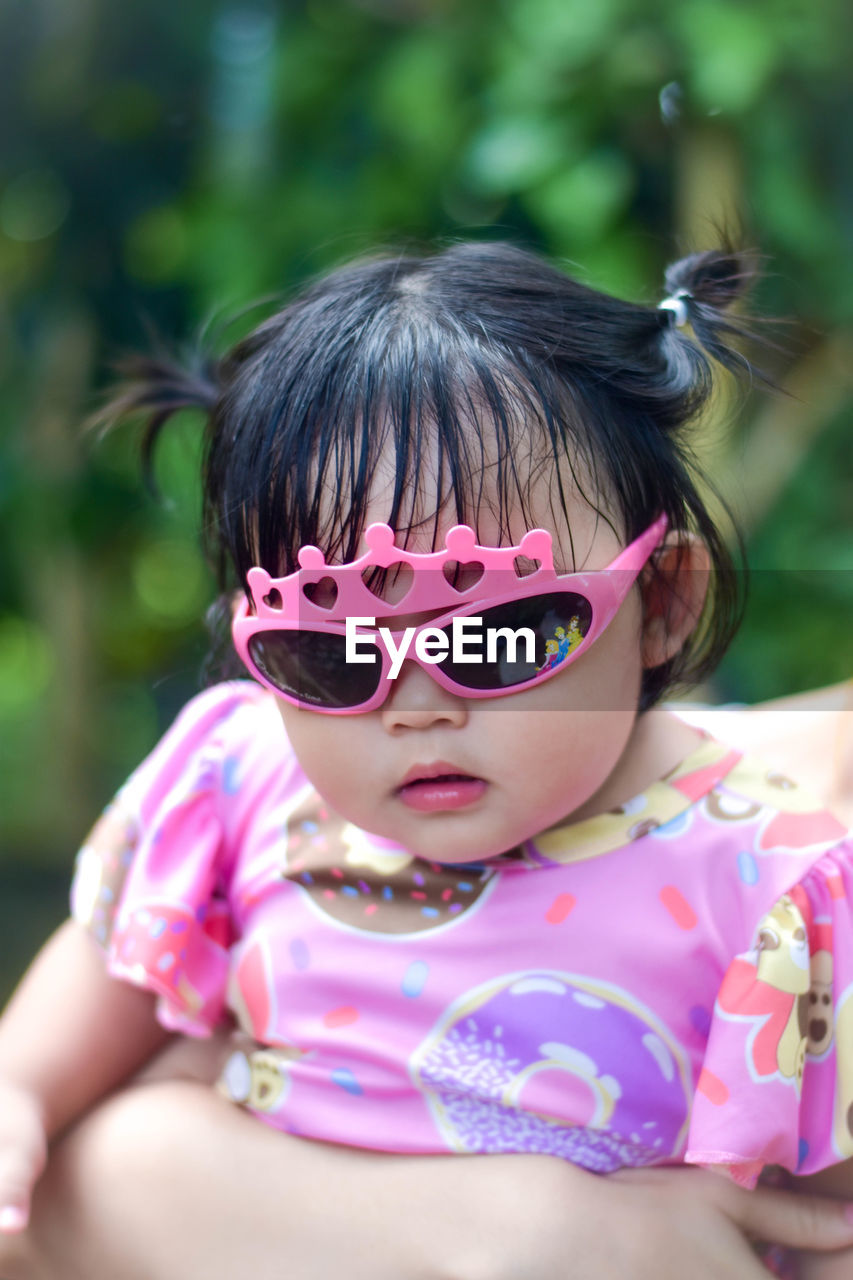 Portrait of young woman wearing sunglasses while standing outdoors