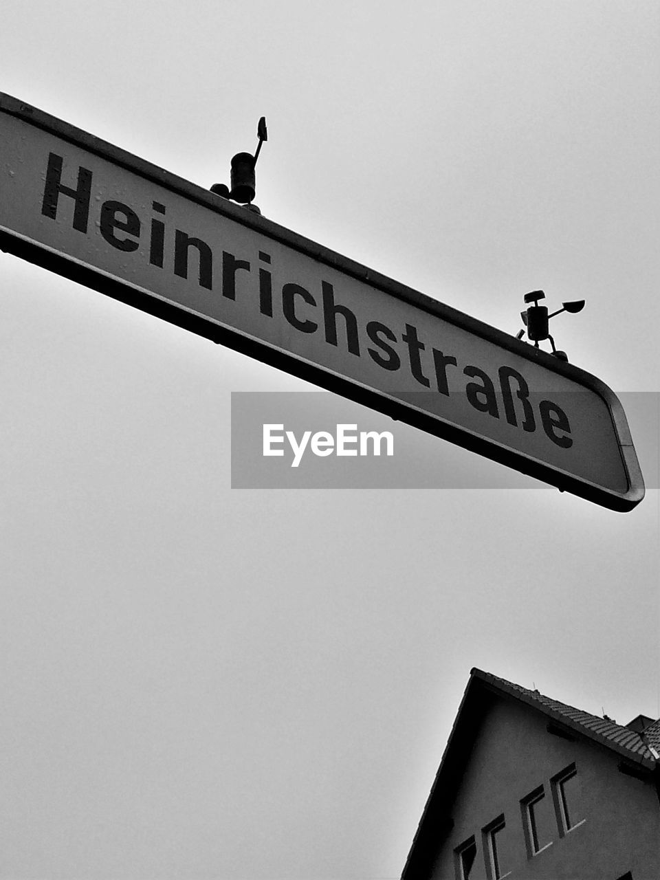 Low angle view of signboard in city against clear sky