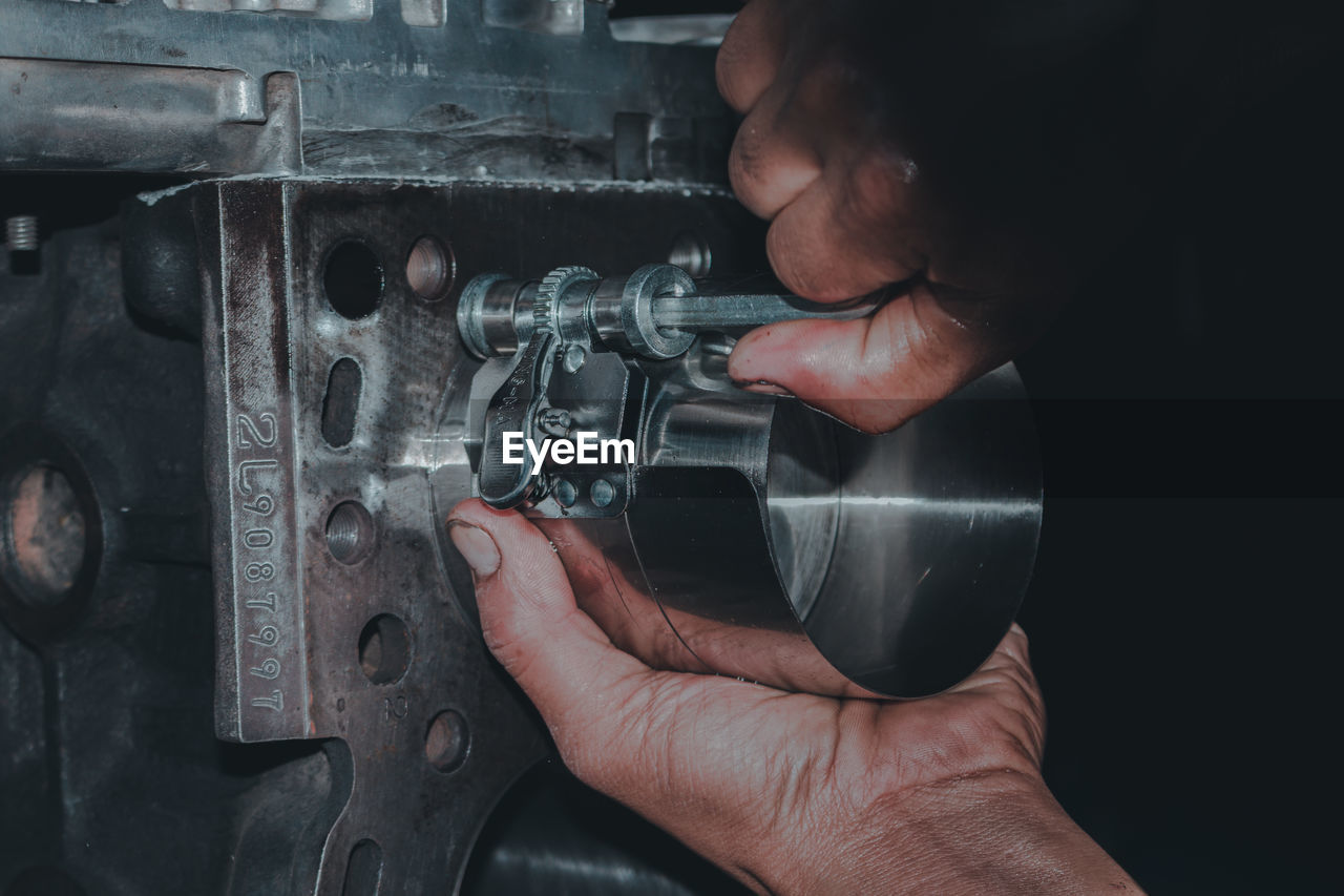 Cropped hand of man repairing machinery