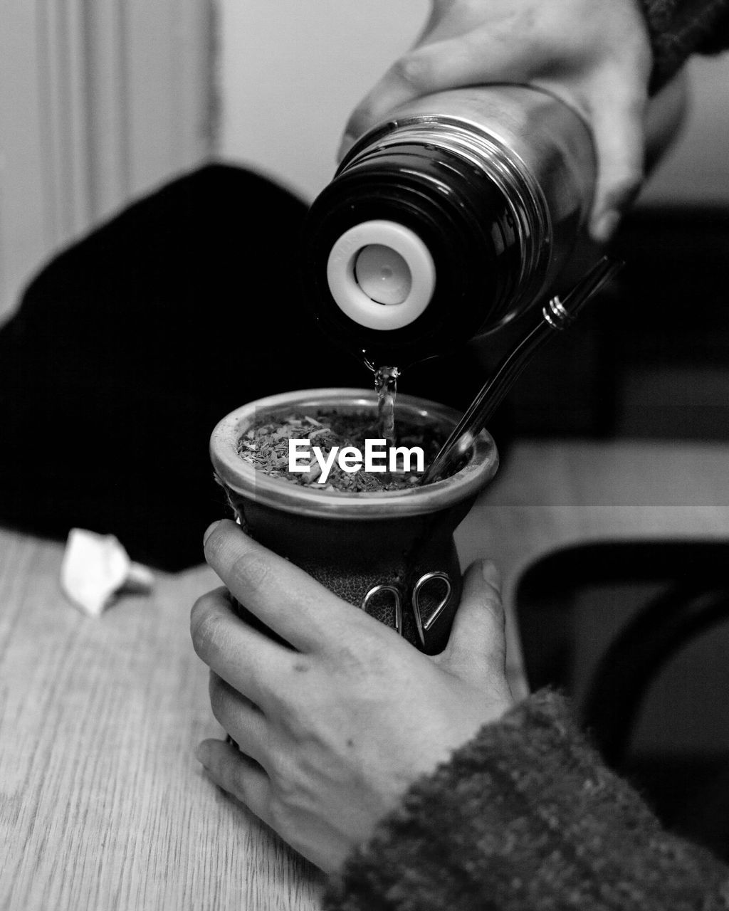 Close-up of person pouring tea cup