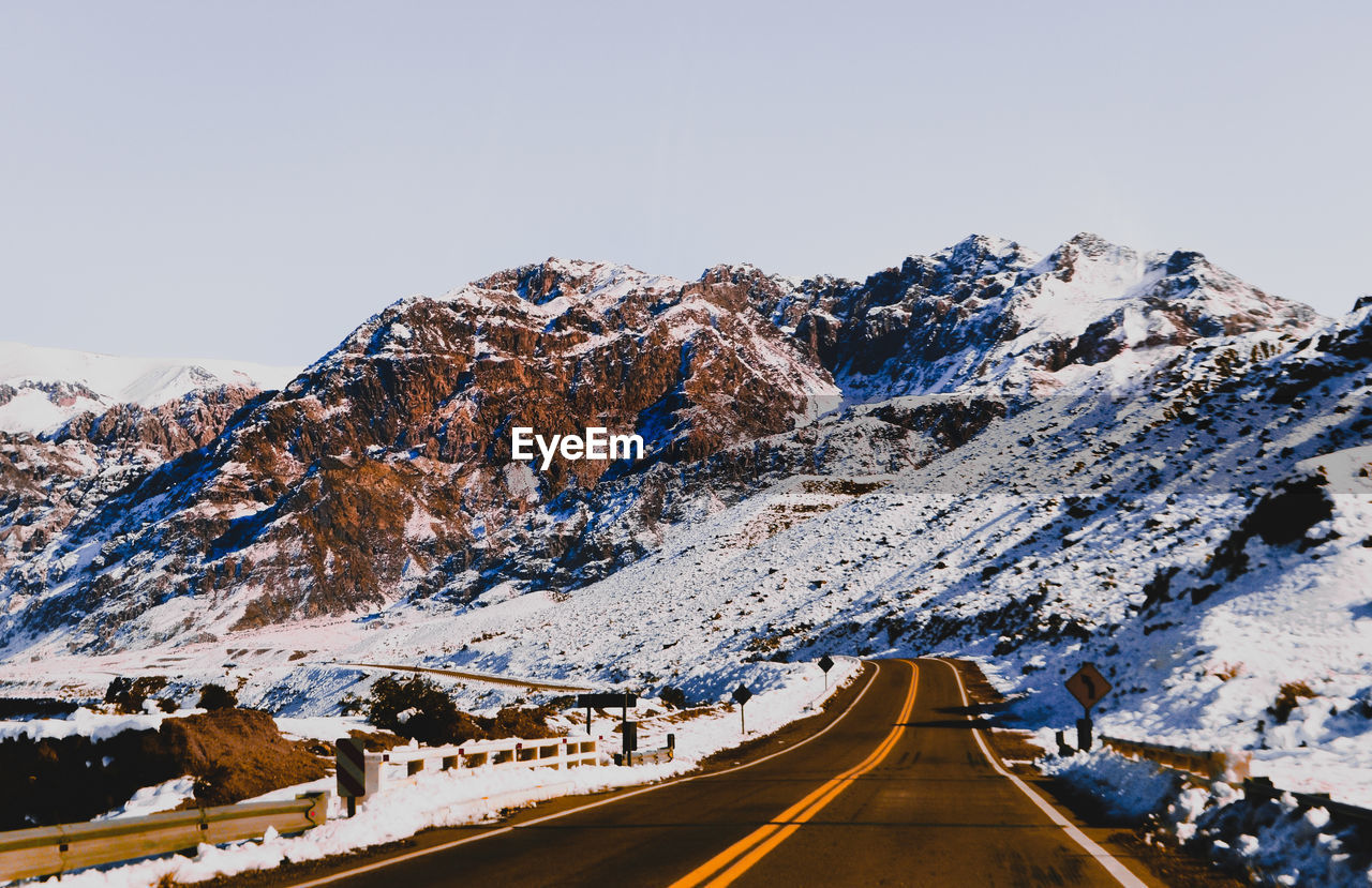 SNOW COVERED ROAD AGAINST SKY