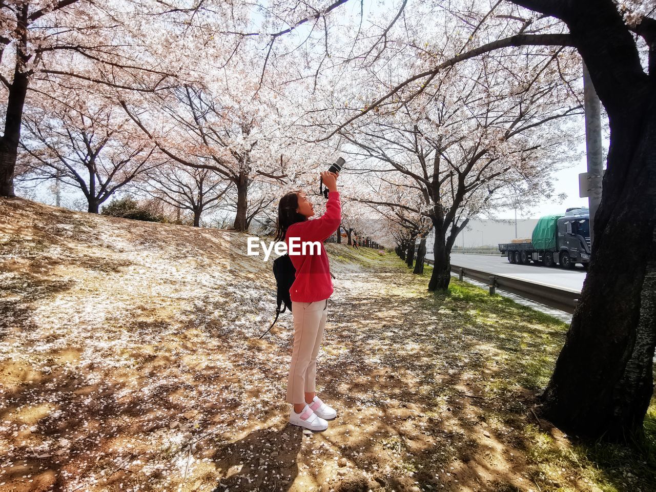 FULL LENGTH REAR VIEW OF WOMAN WALKING ON FOOTPATH