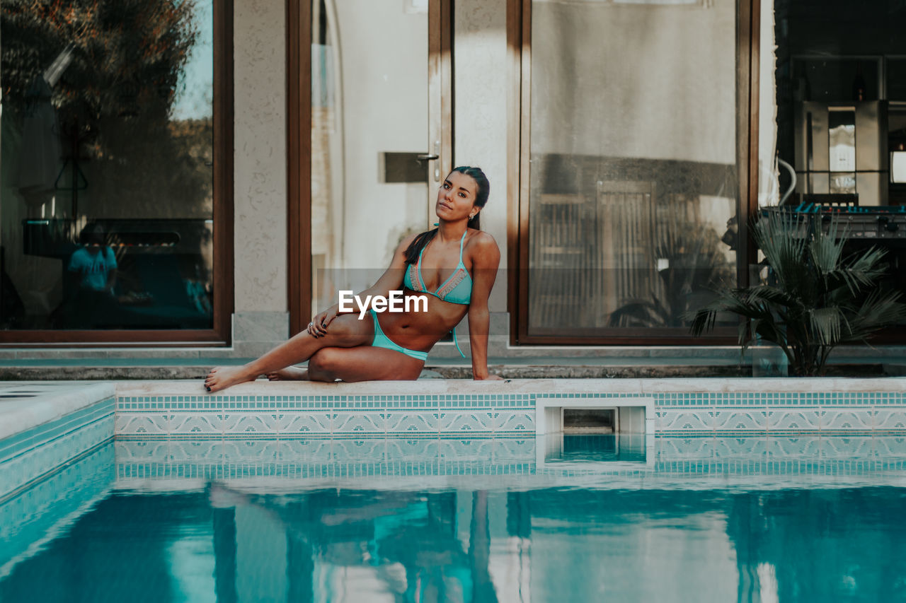 Portrait of sensuous woman sitting by poolside