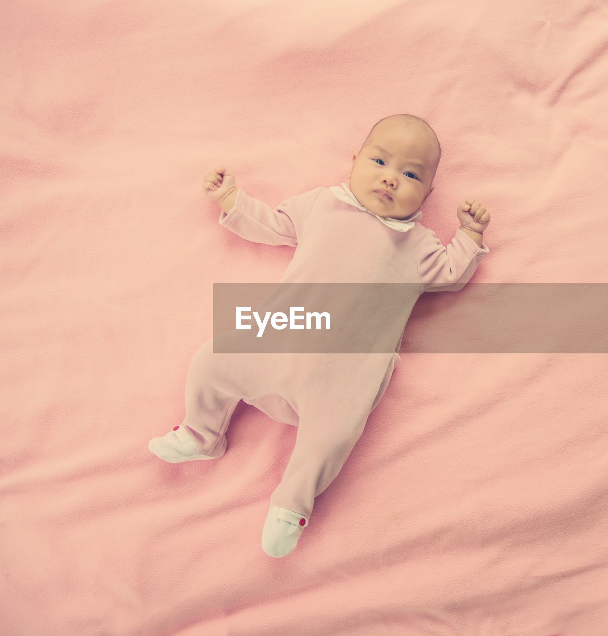 HIGH ANGLE VIEW OF CHILD LYING ON BED