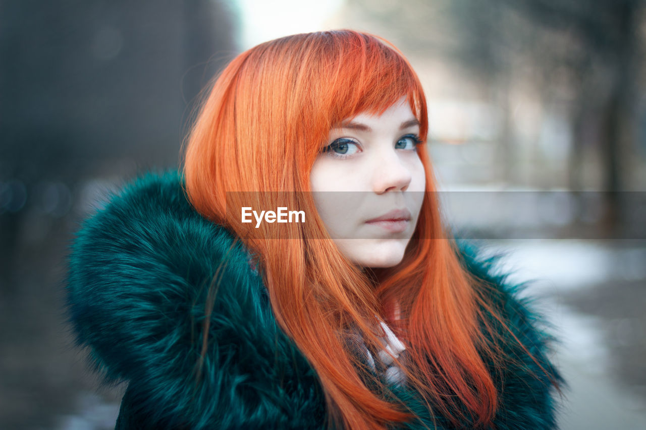 Close-up portrait of young woman wearing fur coat during winter