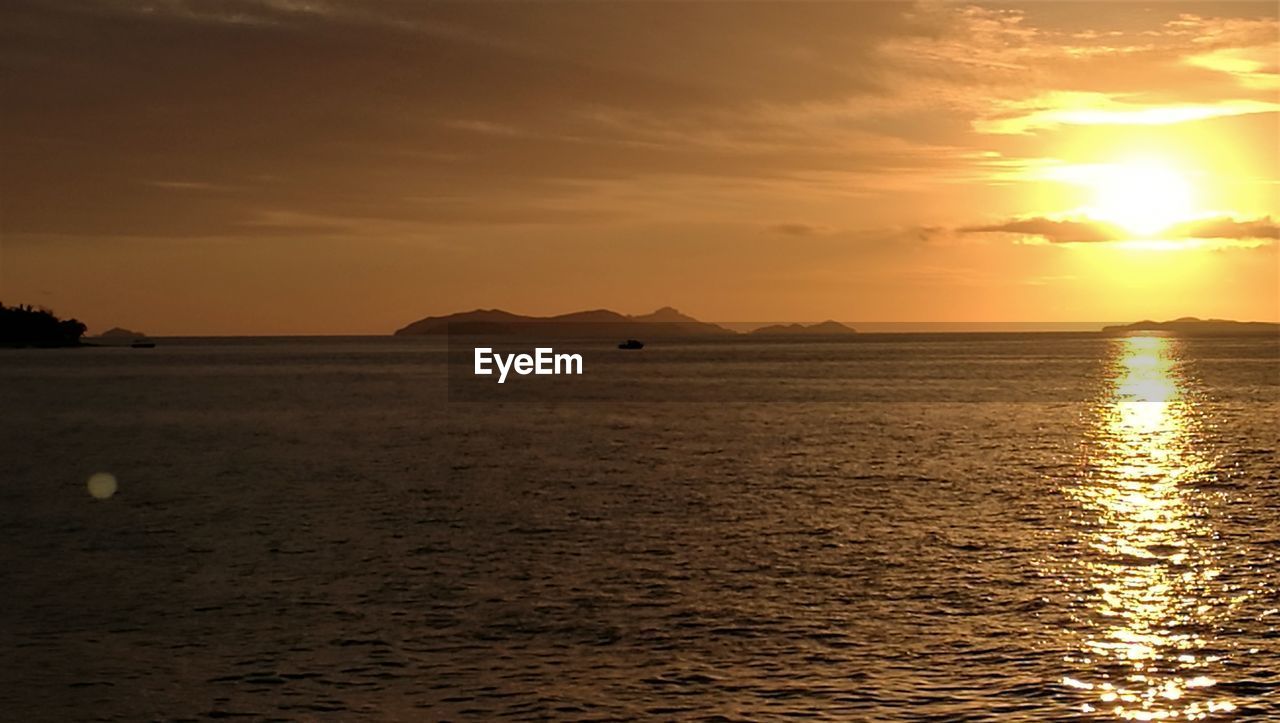 SCENIC VIEW OF SEA AGAINST ORANGE SKY DURING SUNSET