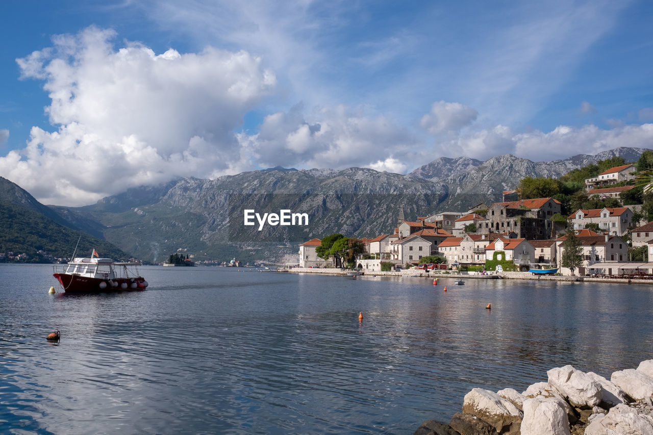 Scenic view of sea by townscape against sky