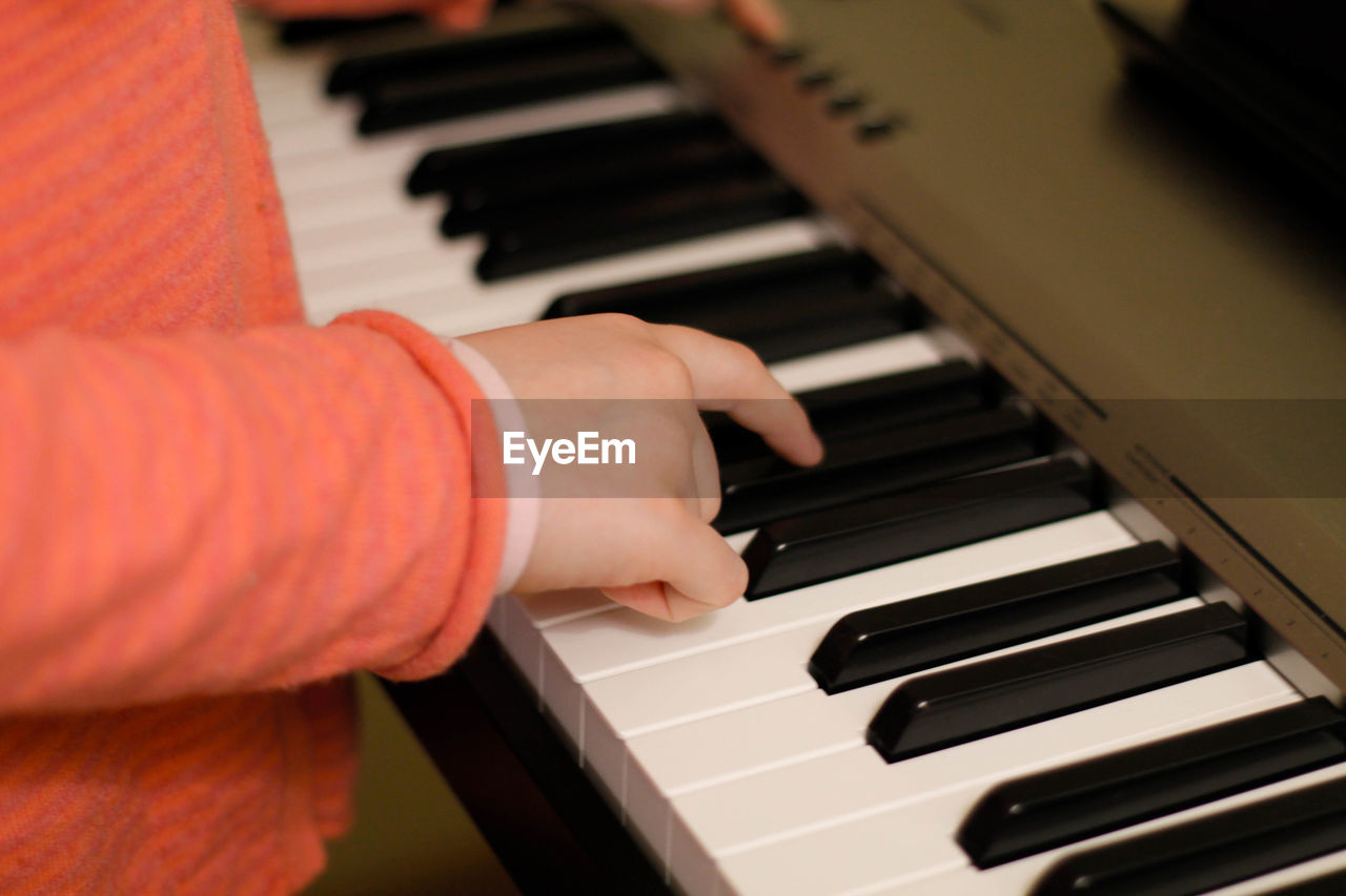 Cropped hands of boy playing piano