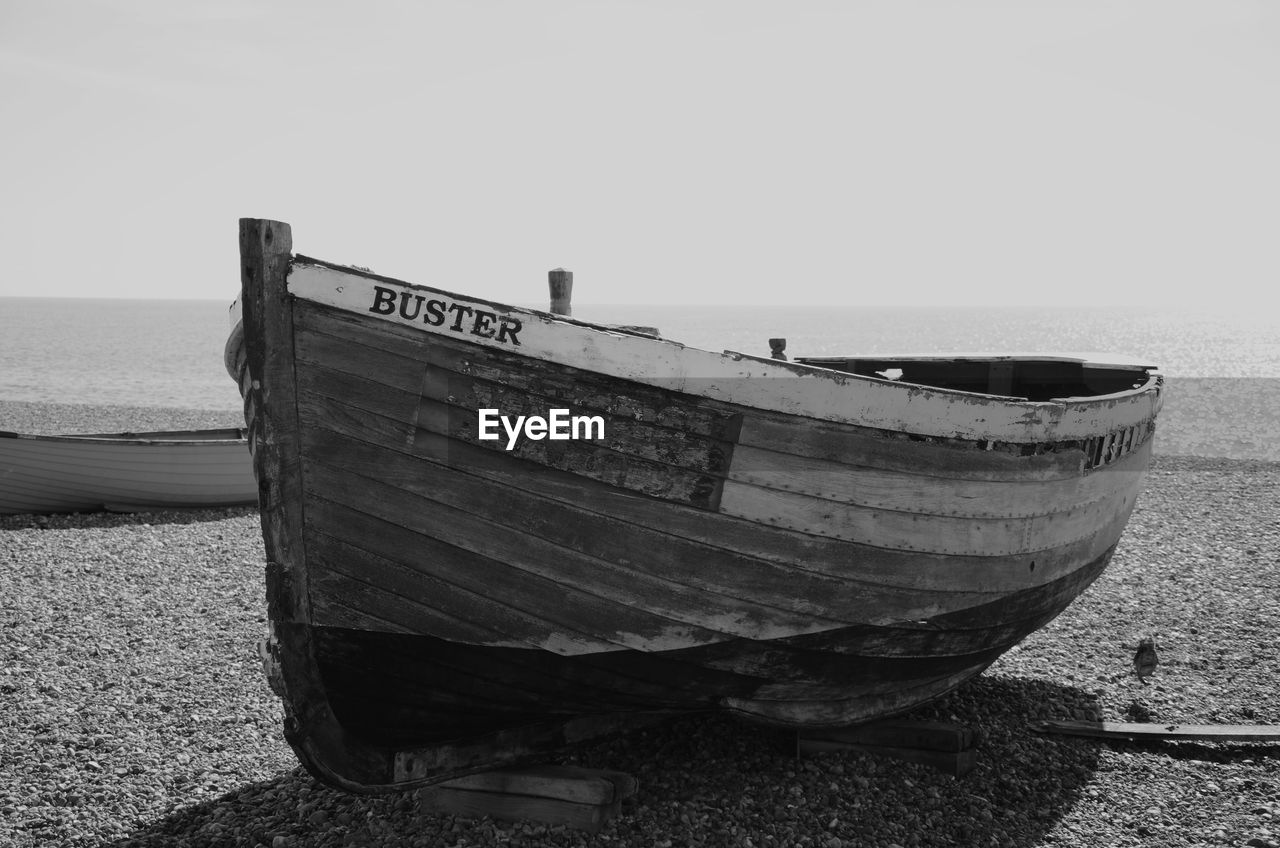 Boat moored on beach against clear sky