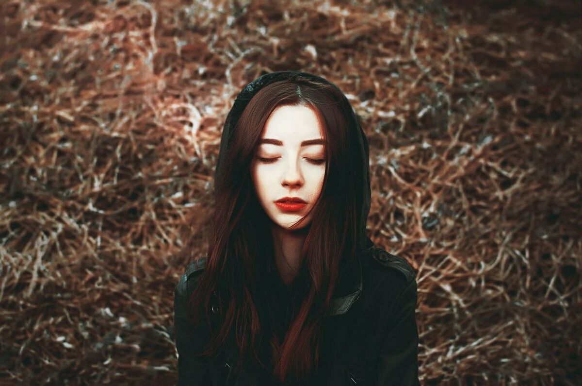 PORTRAIT OF A BEAUTIFUL YOUNG WOMAN LYING ON GROUND