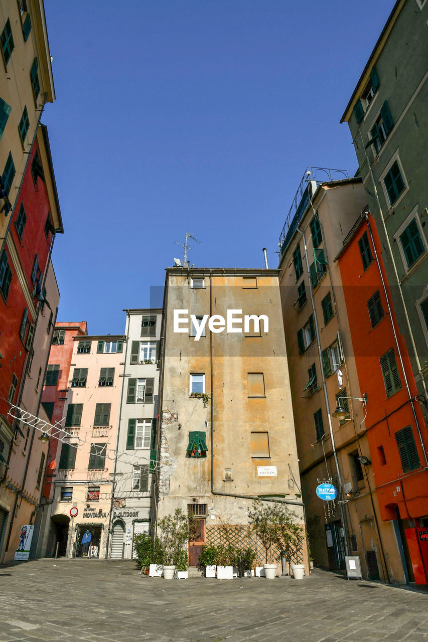 LOW ANGLE VIEW OF BUILDINGS AGAINST BLUE SKY