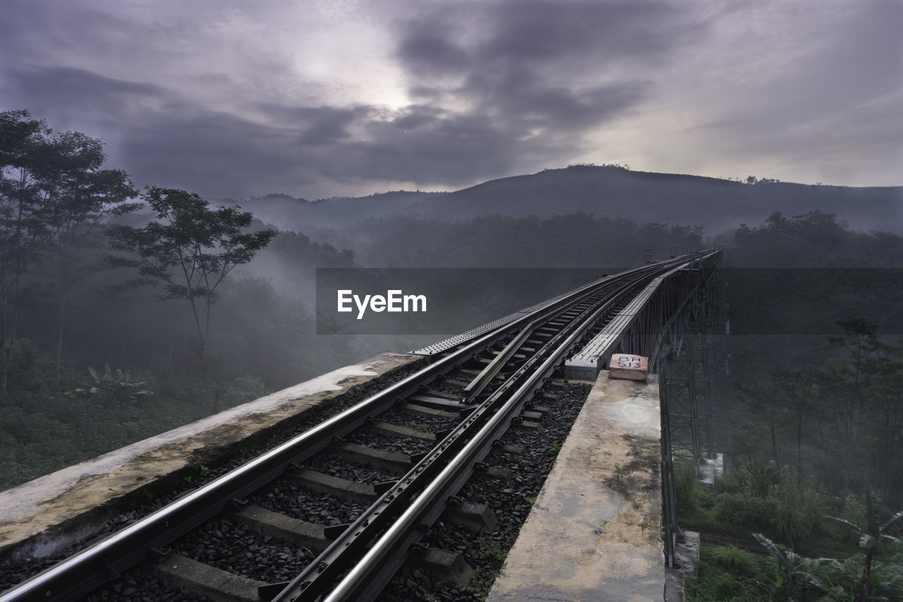 High angle view of railroad tracks against sky, with fog