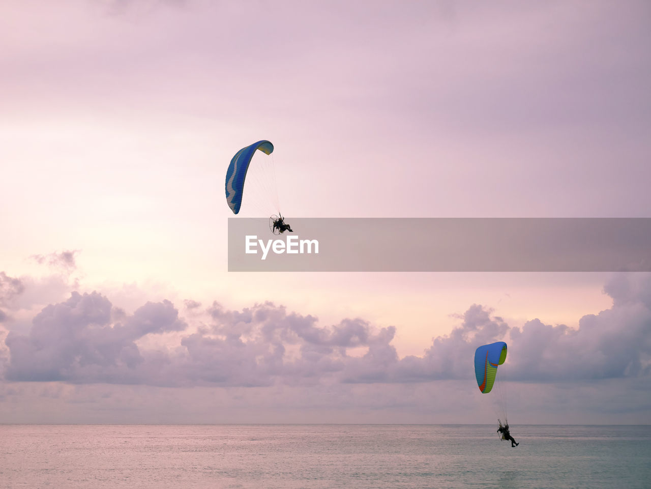 Powered paragliding or paramotor over the sea in evening