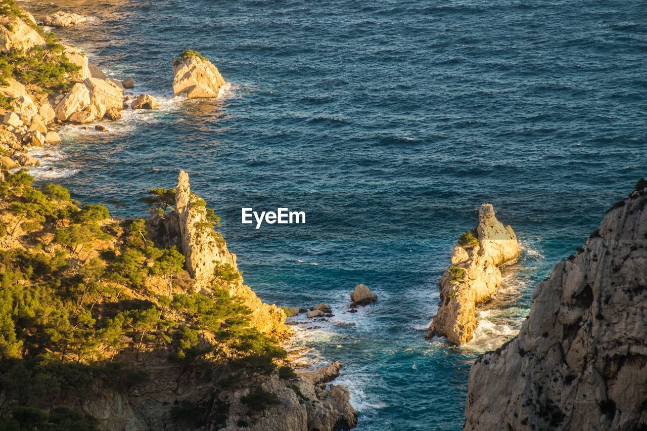 HIGH ANGLE VIEW OF ROCKS AT SEA