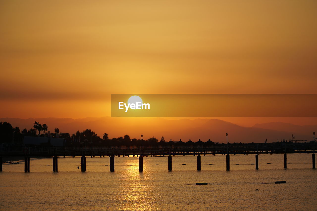 SCENIC VIEW OF SEA AGAINST ORANGE SUNSET SKY