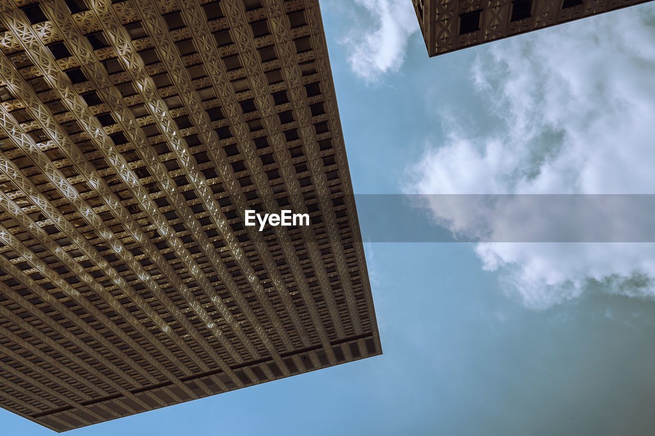 LOW ANGLE VIEW OF BUILDINGS AGAINST CLOUDY SKY