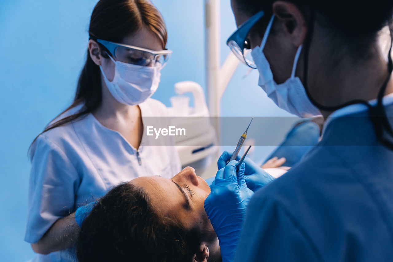 Dentists examining patient in clinic