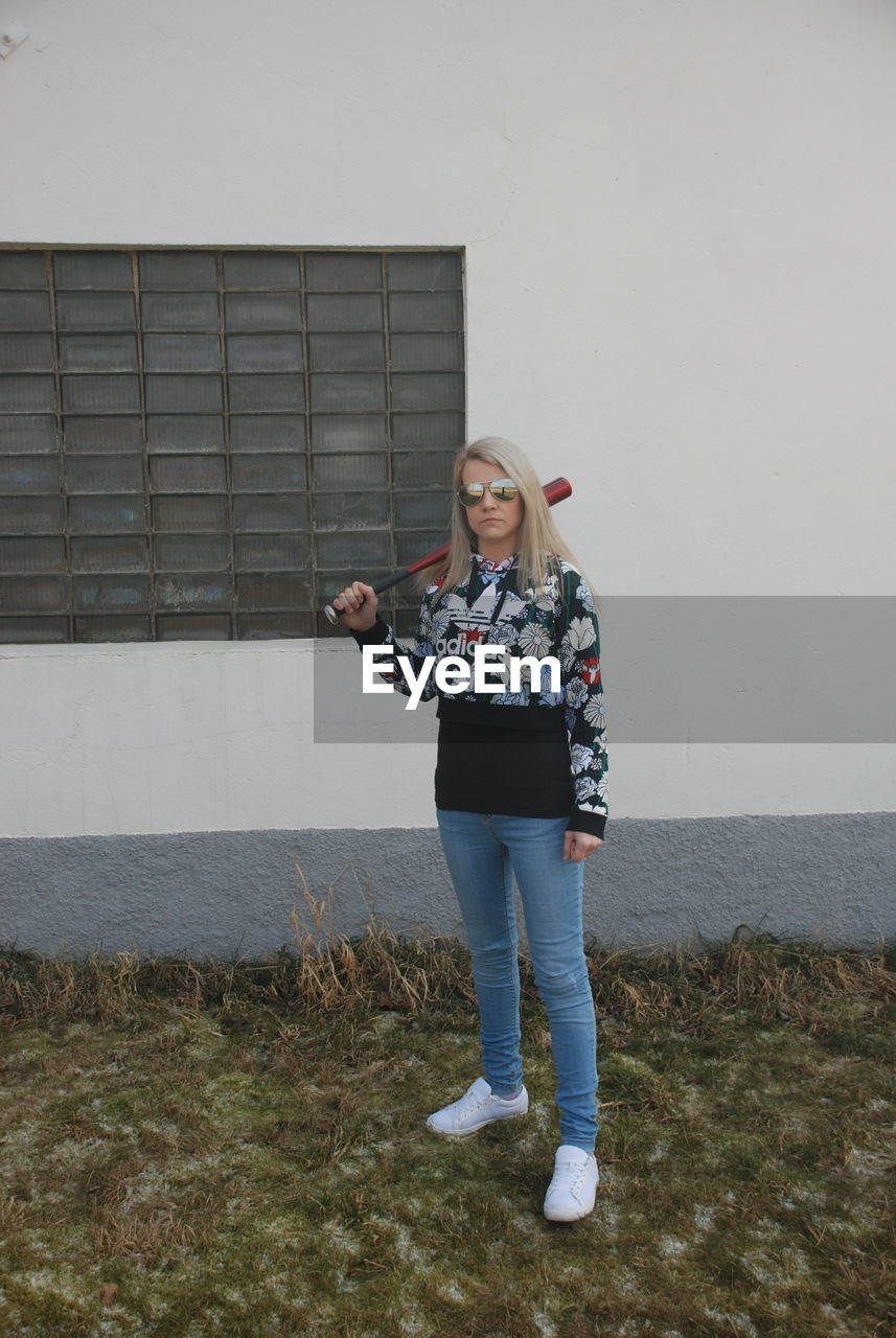 WOMAN STANDING AGAINST WALL