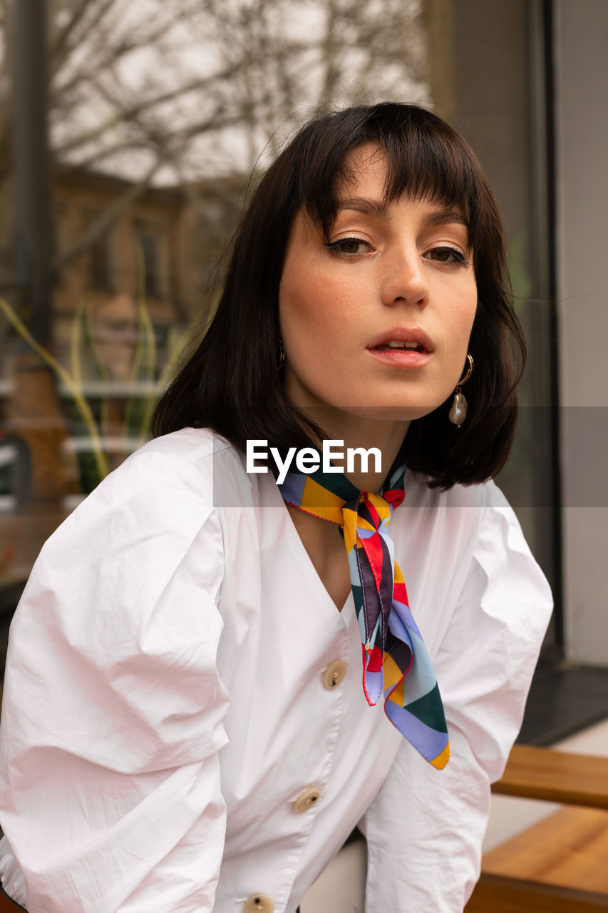 Portrait of young woman sitting outdoors