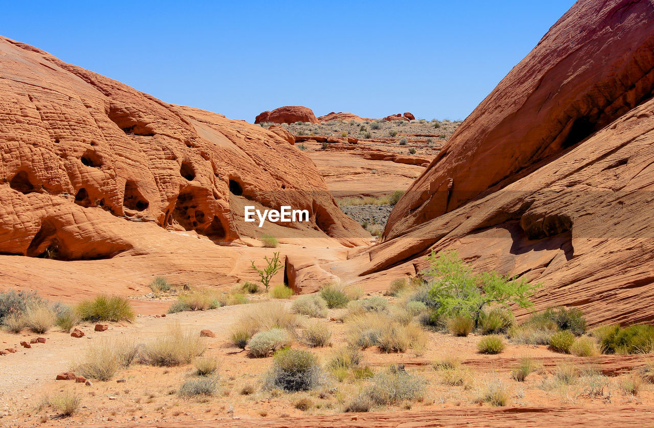 Rock formations on landscape against blue sky