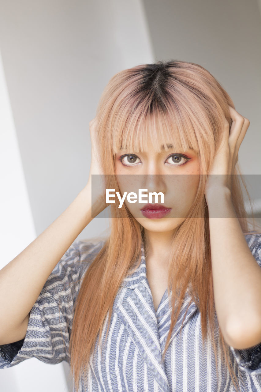 Portrait of beautiful young woman with hairstyle at home