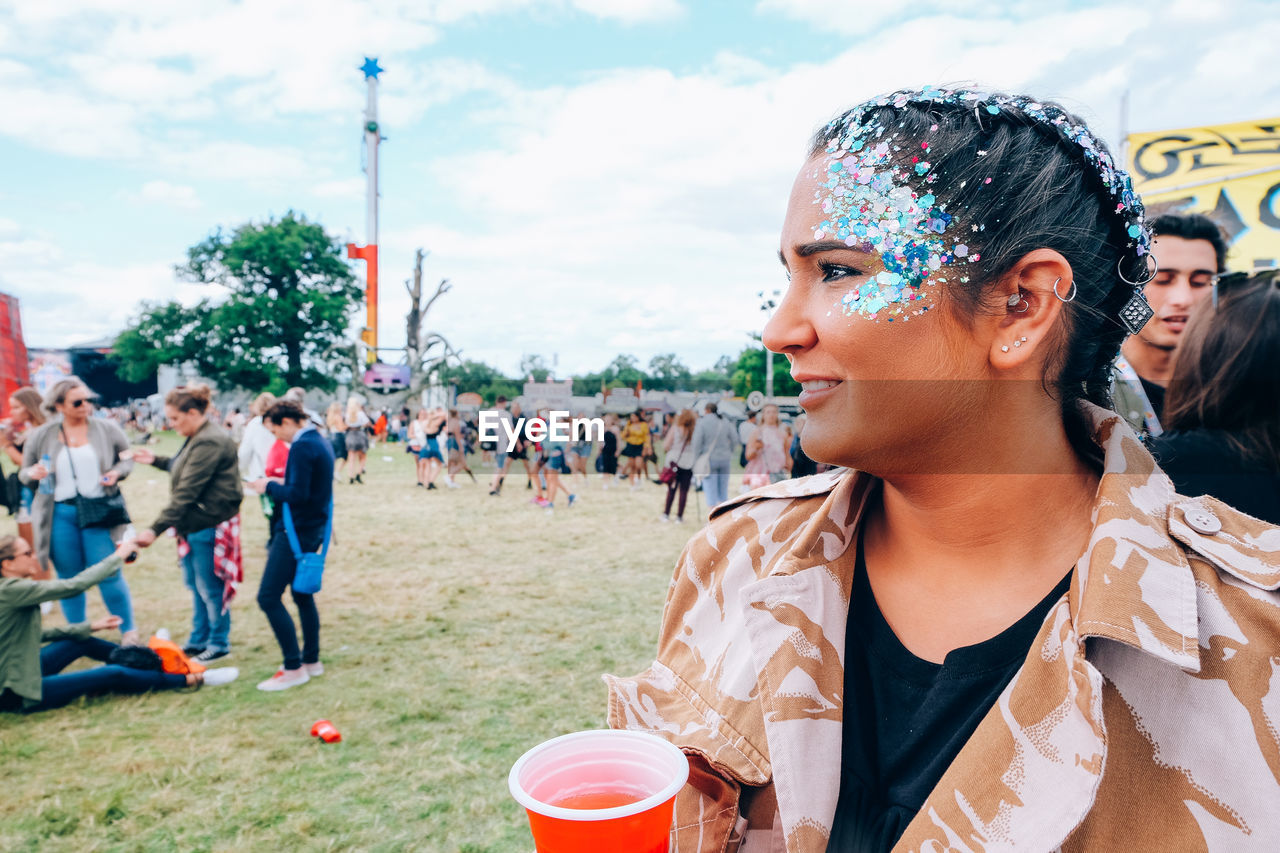 Smiling young woman with drink looking away at party