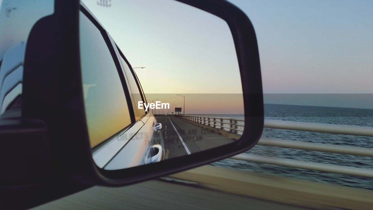 REFLECTION OF SUNSET IN SIDE-VIEW MIRROR
