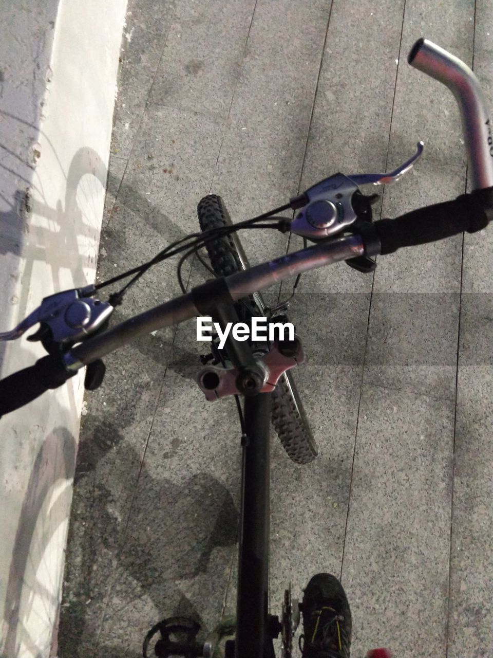 HIGH ANGLE VIEW OF BICYCLE PARKED ON STREET LIGHT