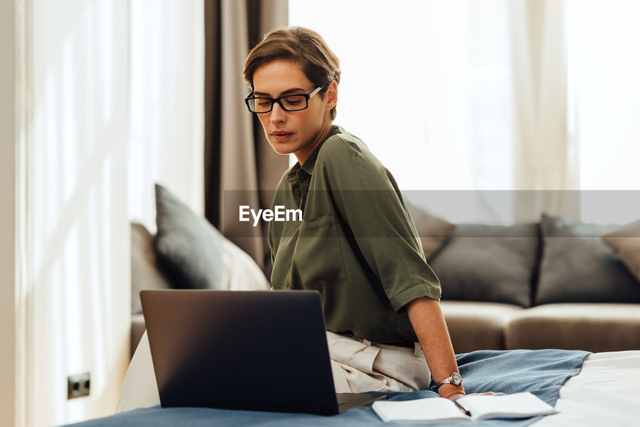 Beautiful woman using laptop sitting at home