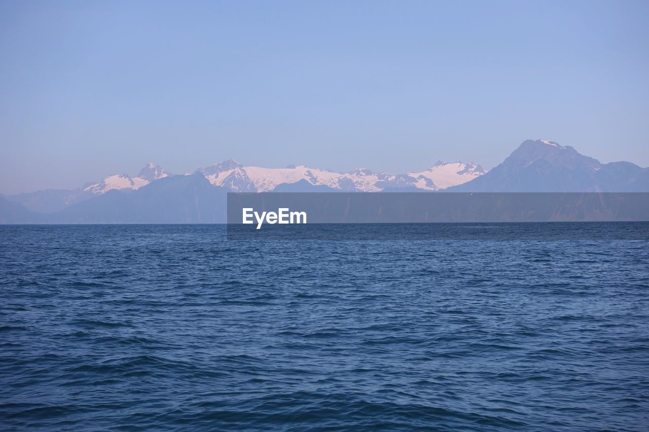 Scenic view of sea and mountains against sky