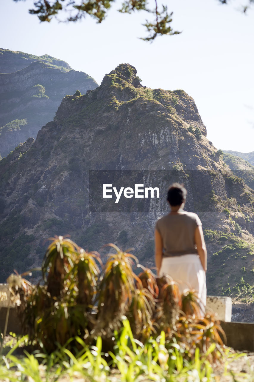 Caucasian woman looks at the mountains on madeira island, portugal