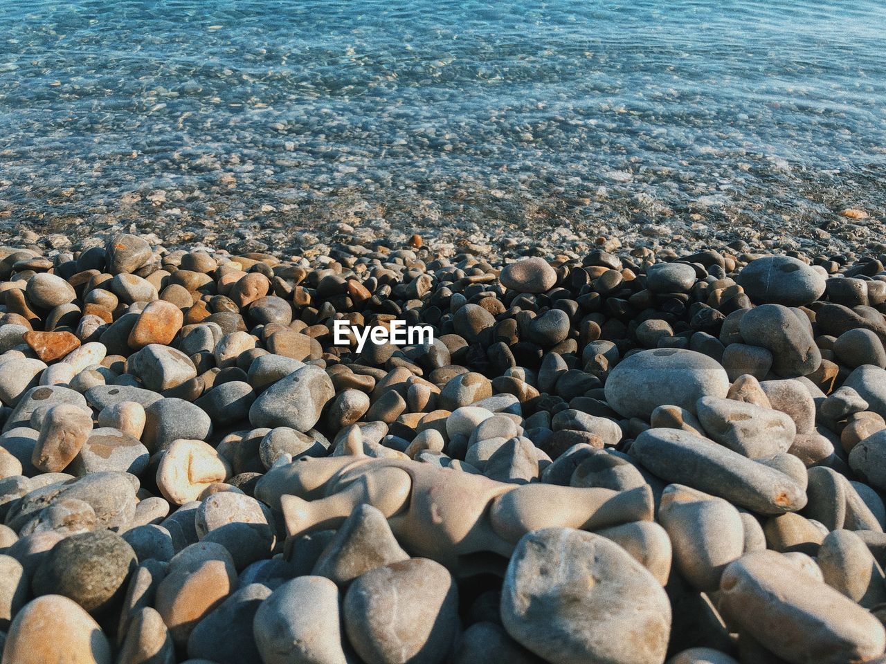 High angle view of pebbles on shore