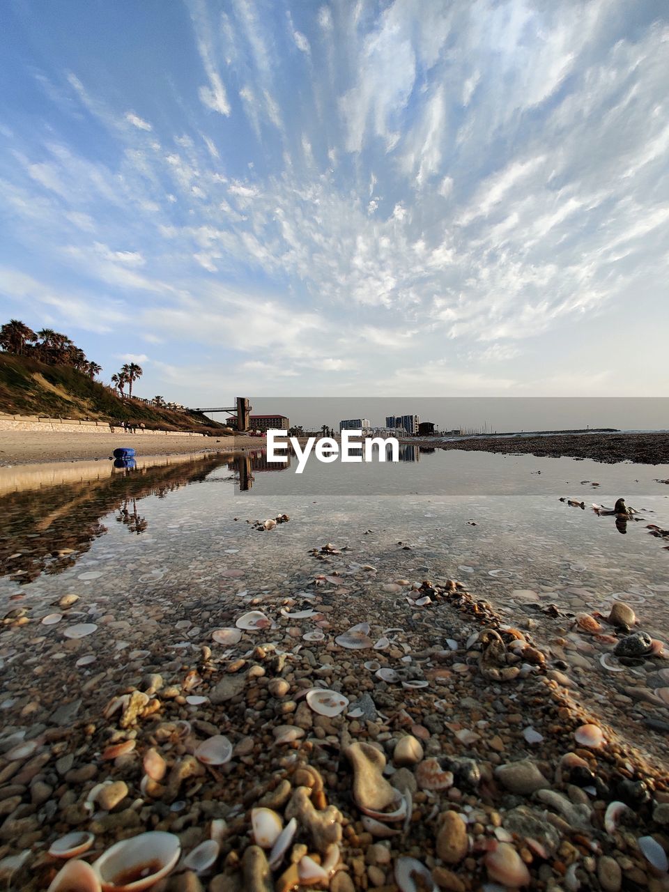 Surface level of stones on beach against sky