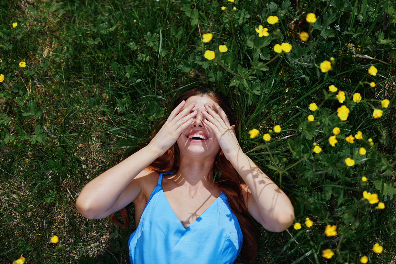 portrait of young woman standing amidst plants on field