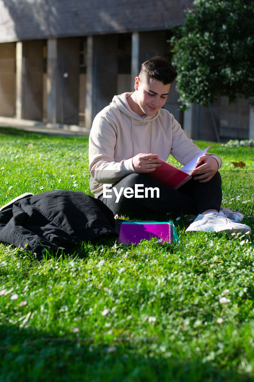 YOUNG MAN ON BOOK IN FIELD