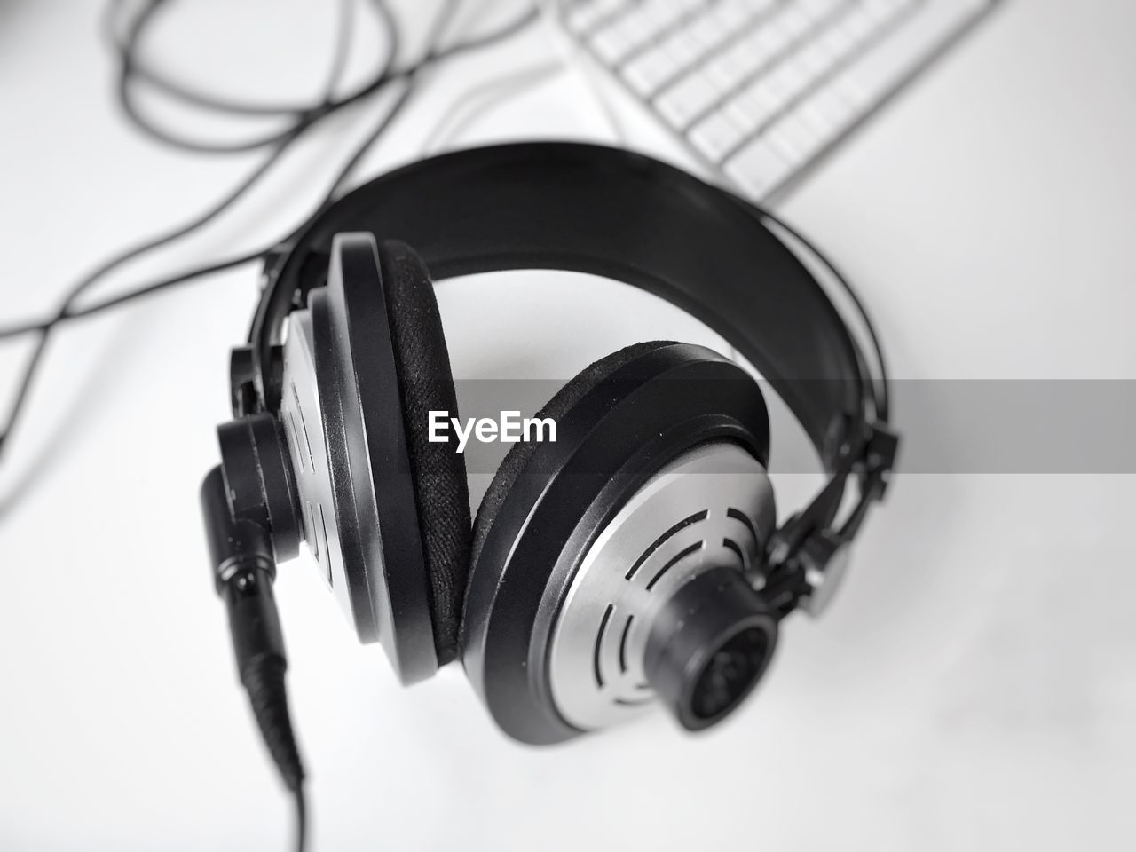 High angle view of headphones and computer keyboard on white background