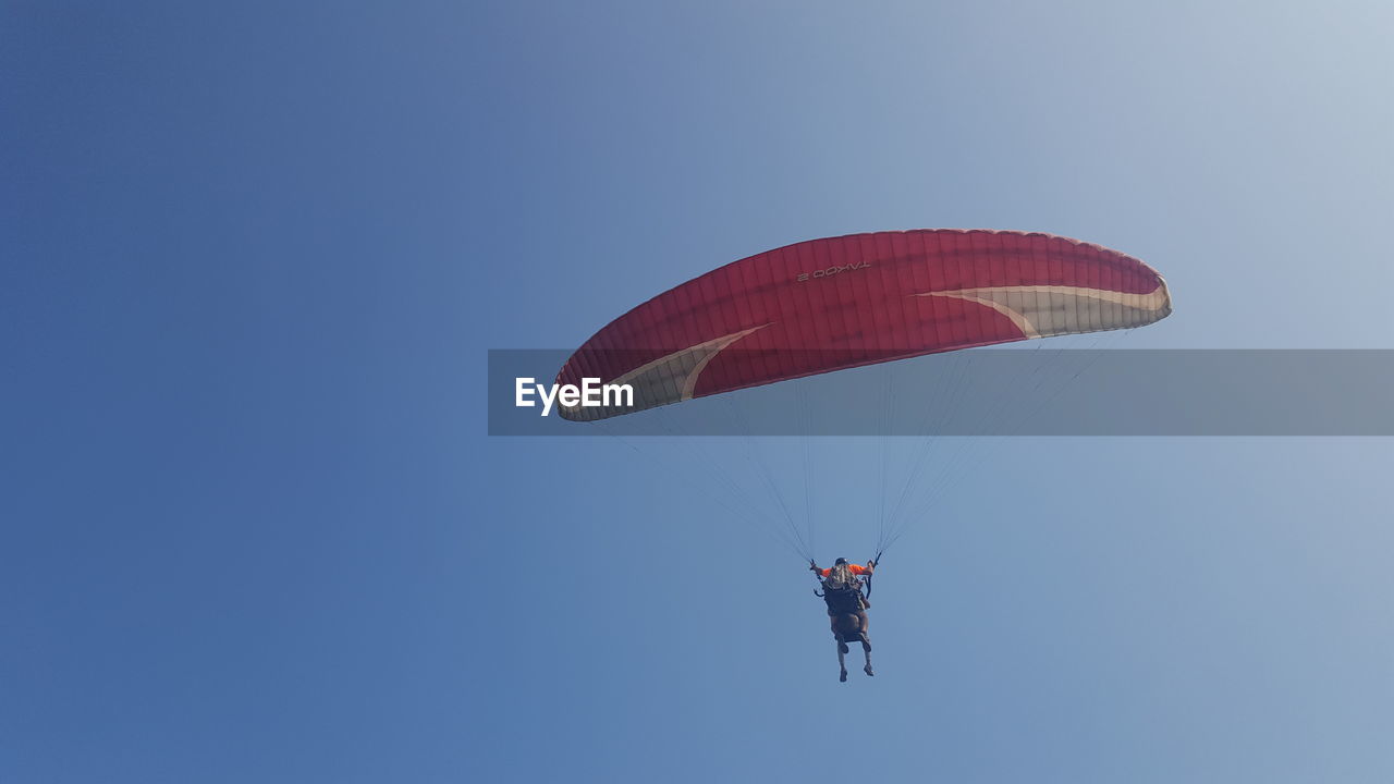 LOW ANGLE VIEW OF PERSON PARAGLIDING AGAINST SKY