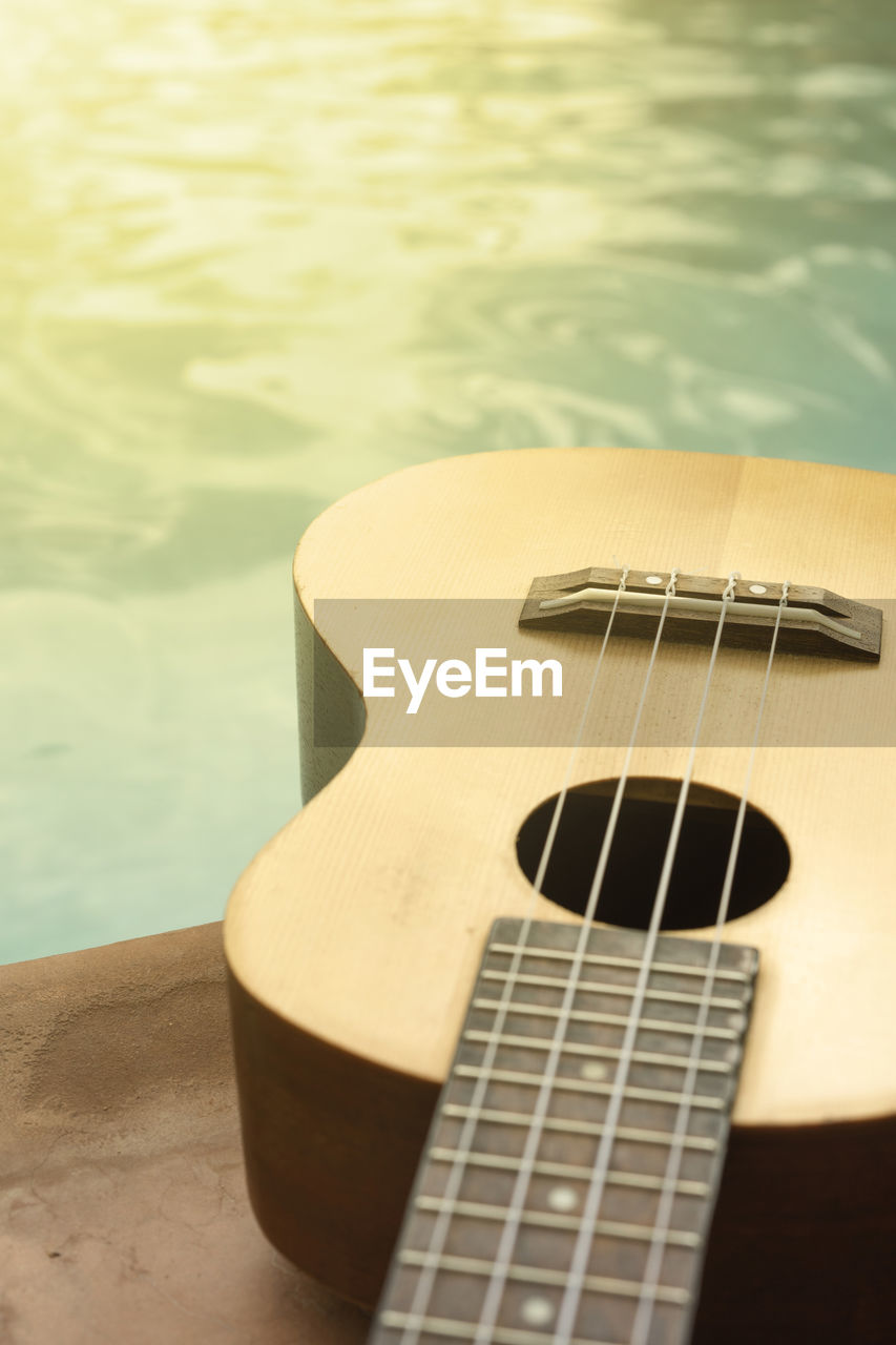Close-up of guitar on table at poolside