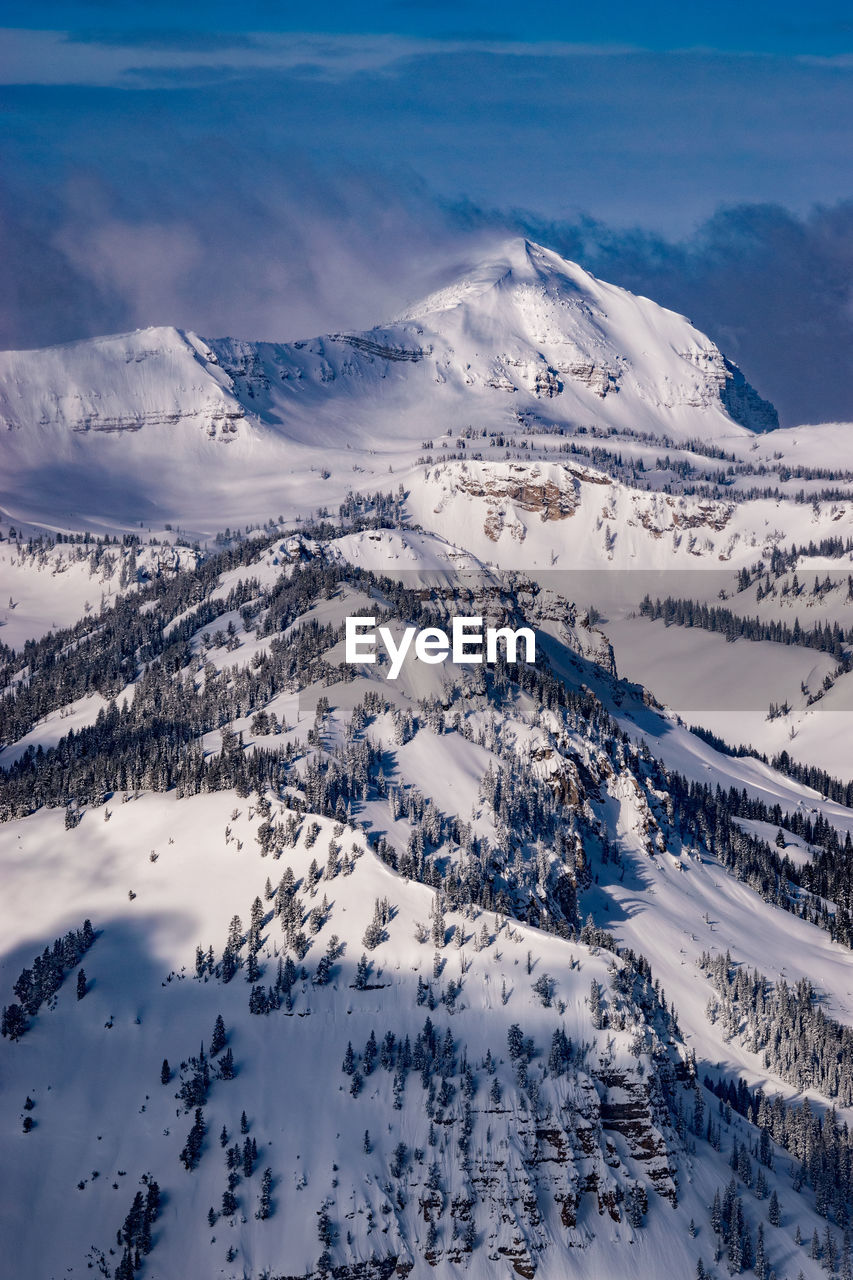 Wintery scene with snowy mountains and clouds