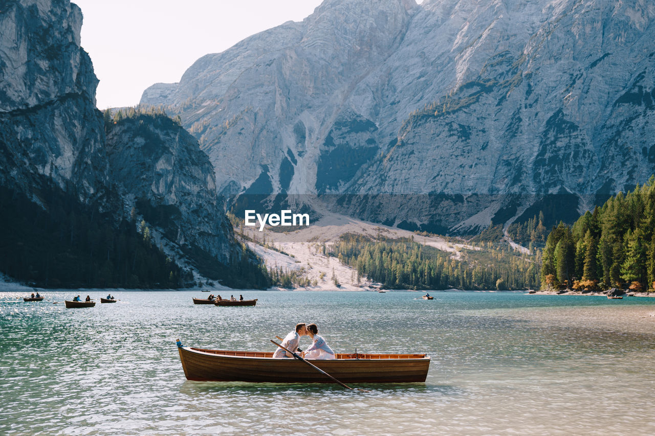 BOAT ON LAKE BY MOUNTAINS