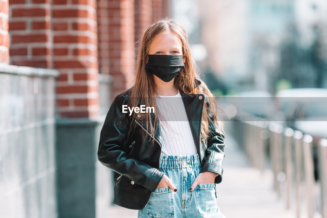 Girl wearing mask while standing outdoors