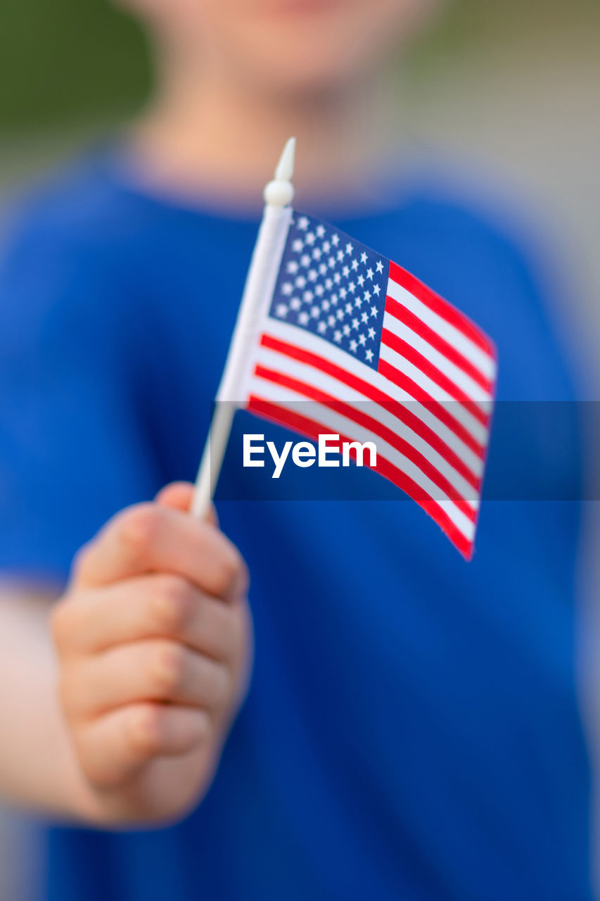 Midsection of boy holding flag