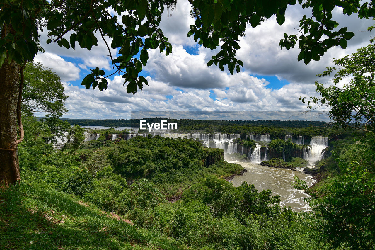Scenic view of landscape against sky - iguazu waterfalls seen through a natural frame