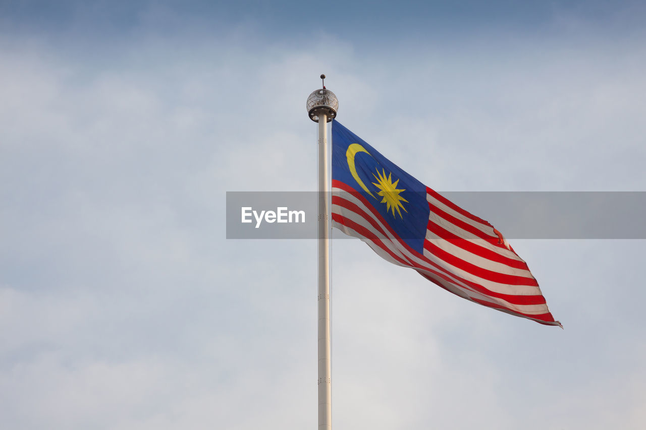 LOW ANGLE VIEW OF RED FLAG AGAINST SKY