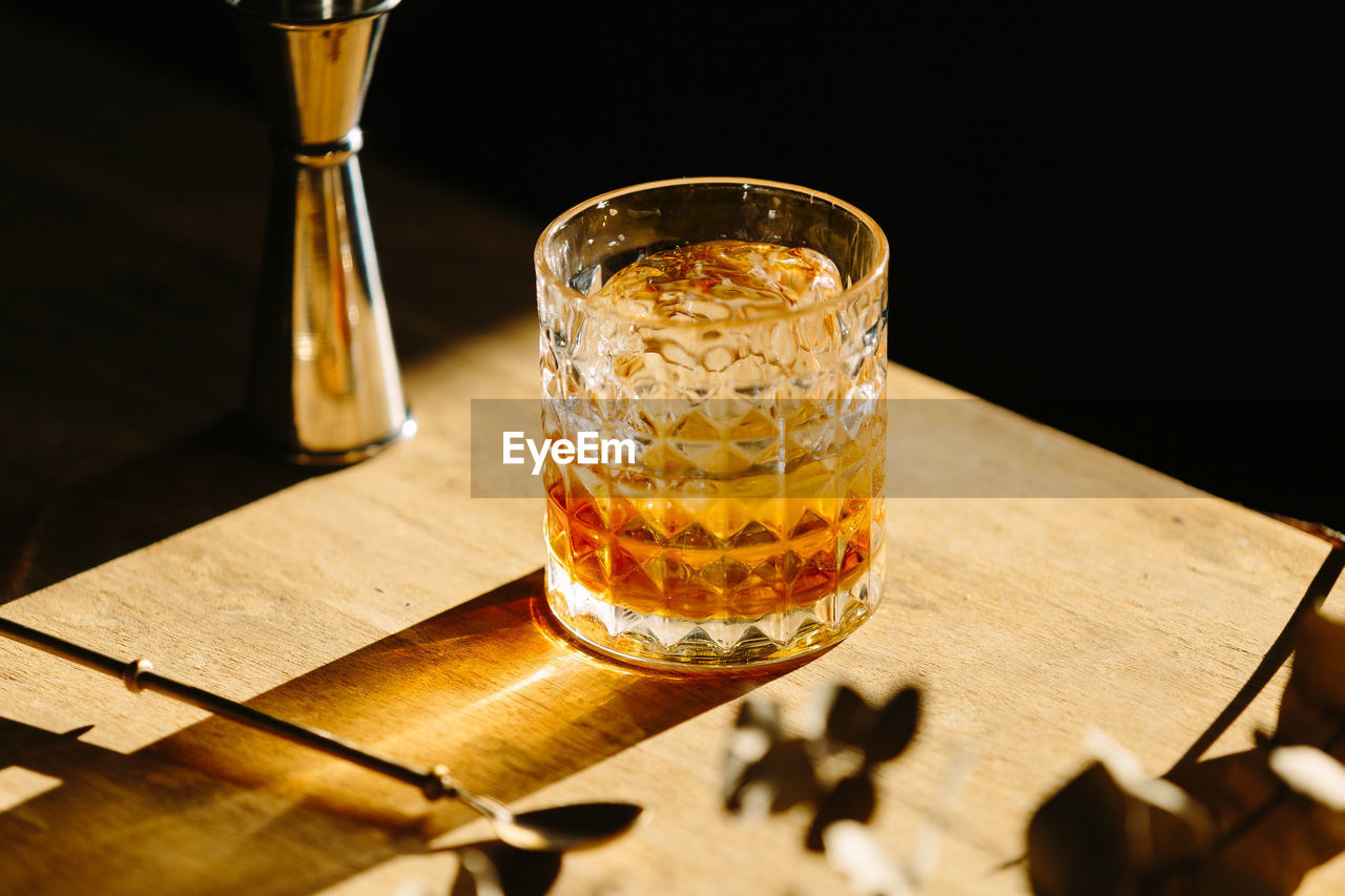 Close-up of glass with bourbon whiskey on table